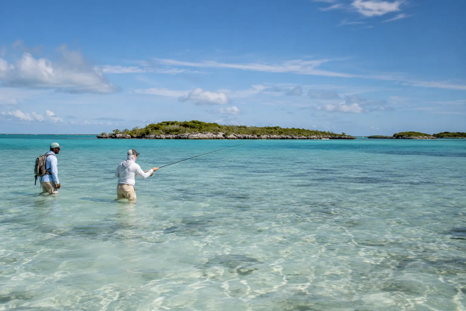 Guide helping an angler fish a shallow flat on foot